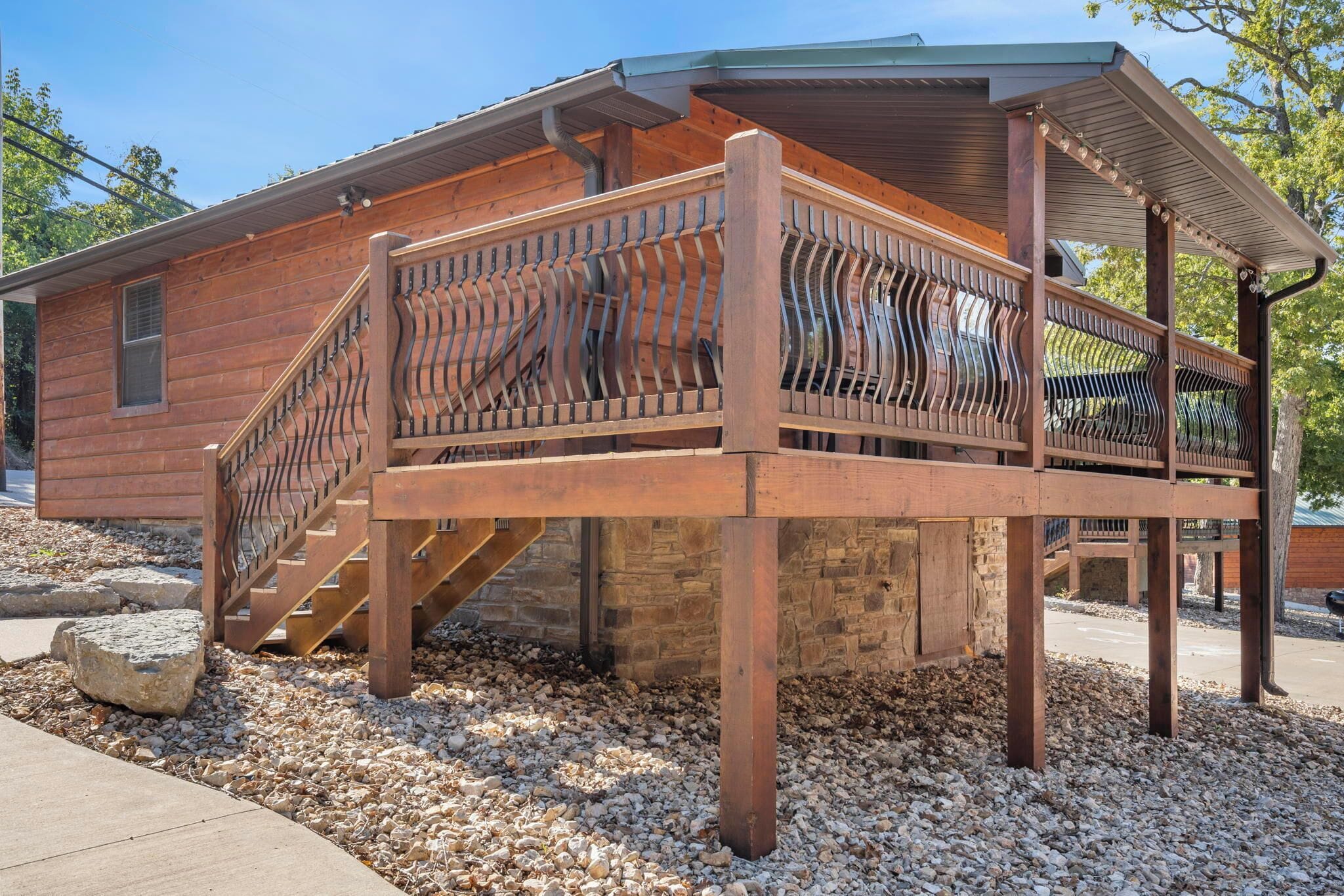 Eine Holzhütte mit einer Holzterrasse und Treppen, die zu einem Fenster führen.