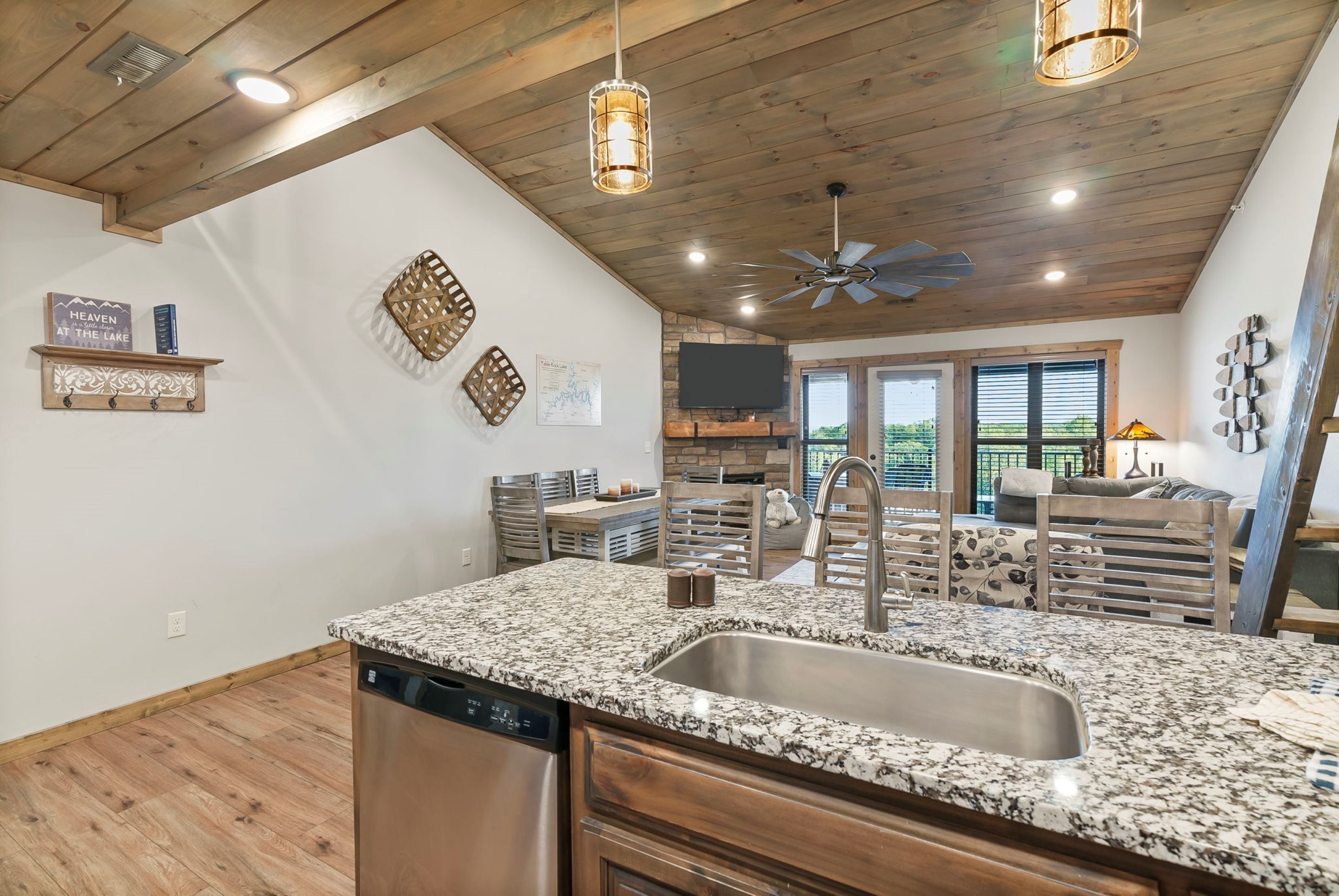 A kitchen with granite countertops, a dishwasher, and a ceiling fan.