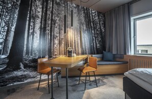 A room with a large window, a bed, a seating area with a sofa and a table with chairs. - Hoje Taastrup Hotel Copenhagen West, a member of Radisson Individuals (Taastrup)