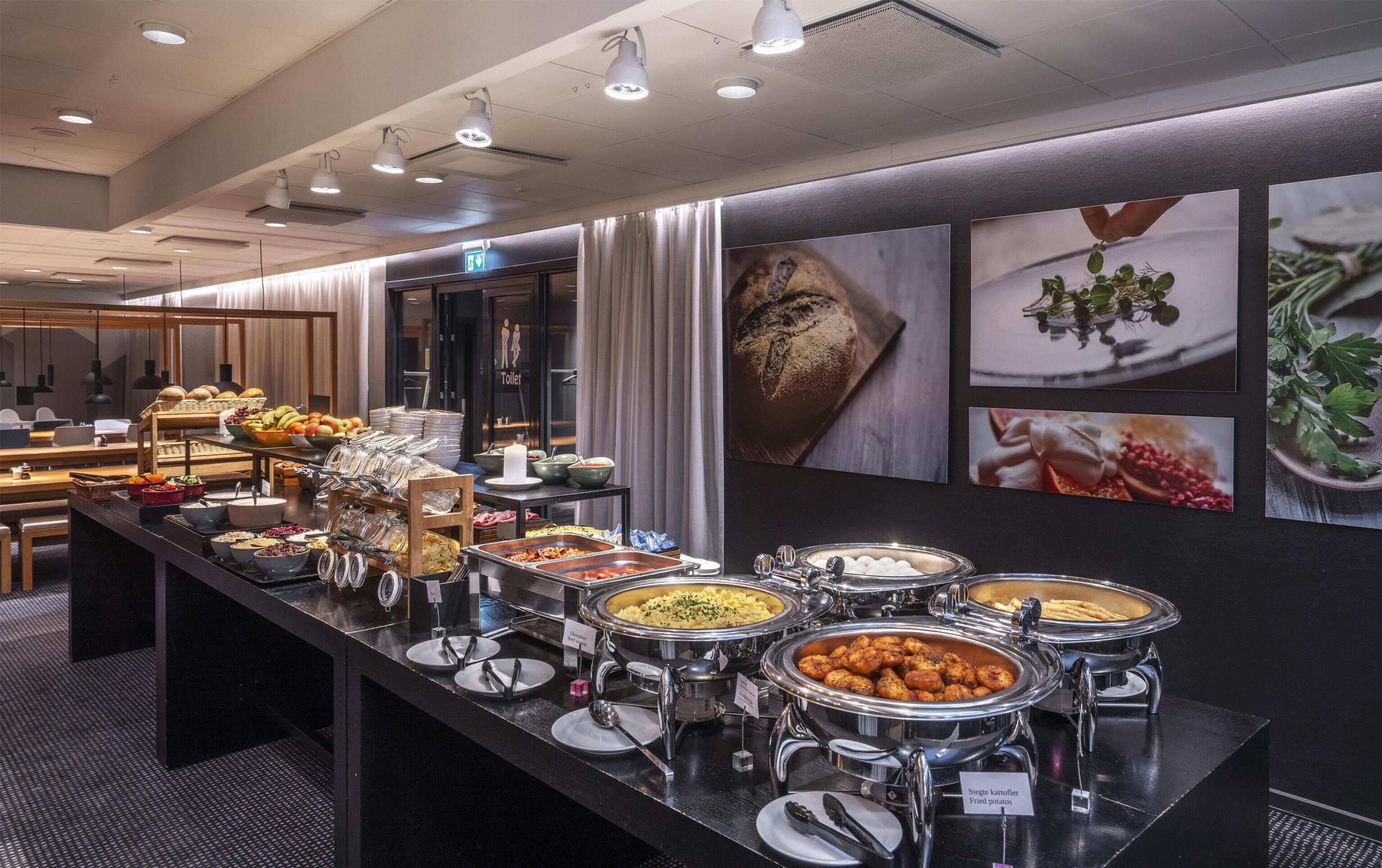 A buffet area with various food options, a restroom, and a seating area with tables and chairs.