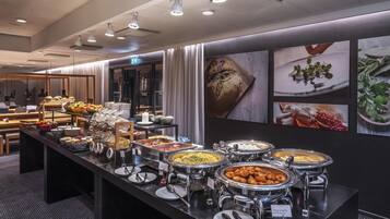 A buffet area with various food options, a restroom, and a seating area with tables and chairs.