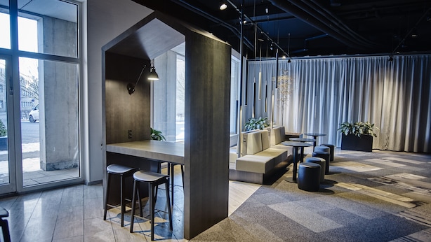 A modern interior with a bar area, seating, and large windows.