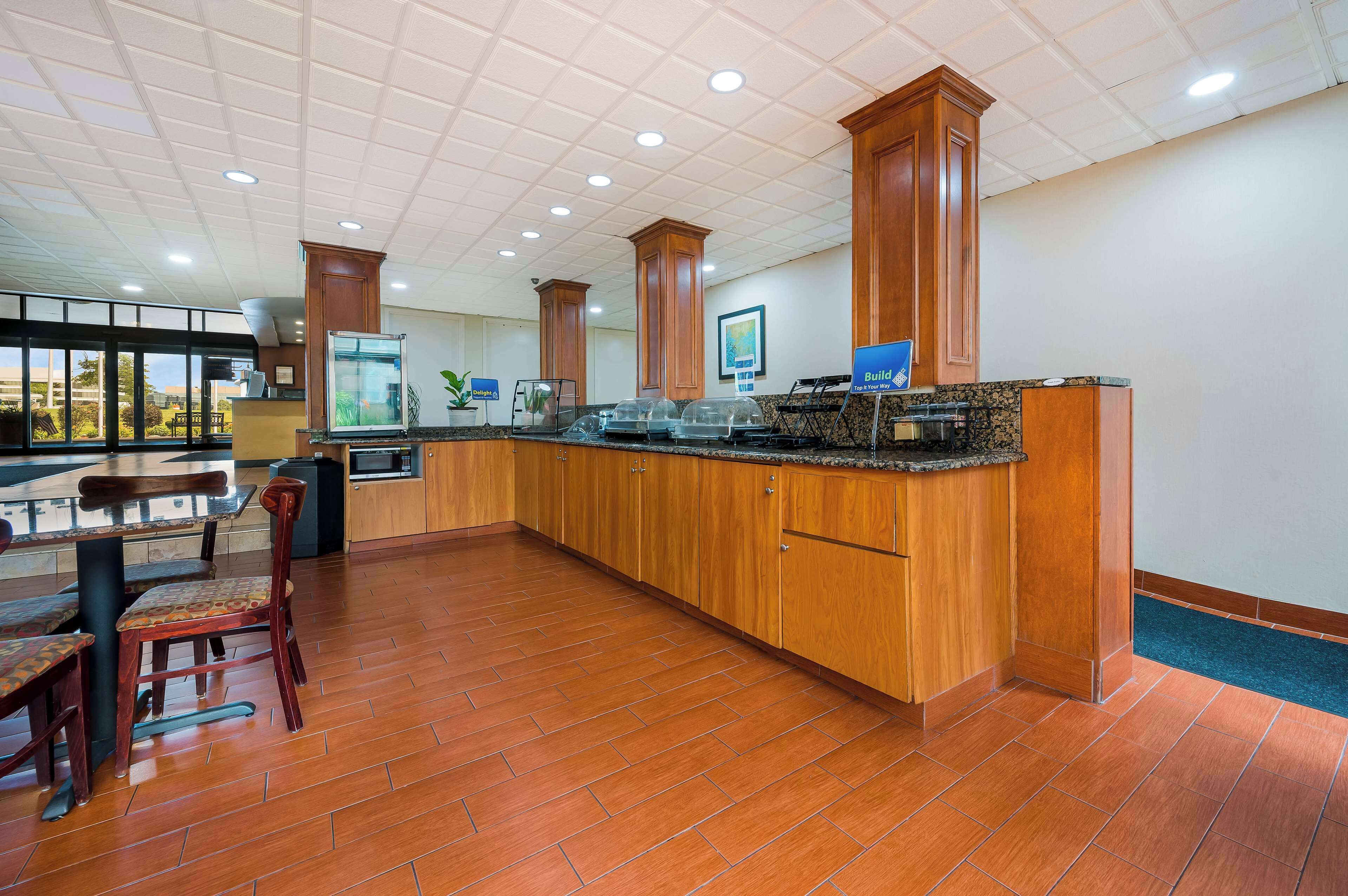 Amplia zona de cocina con armarios de madera, encimera de granito y una mesa de comedor con sillas.