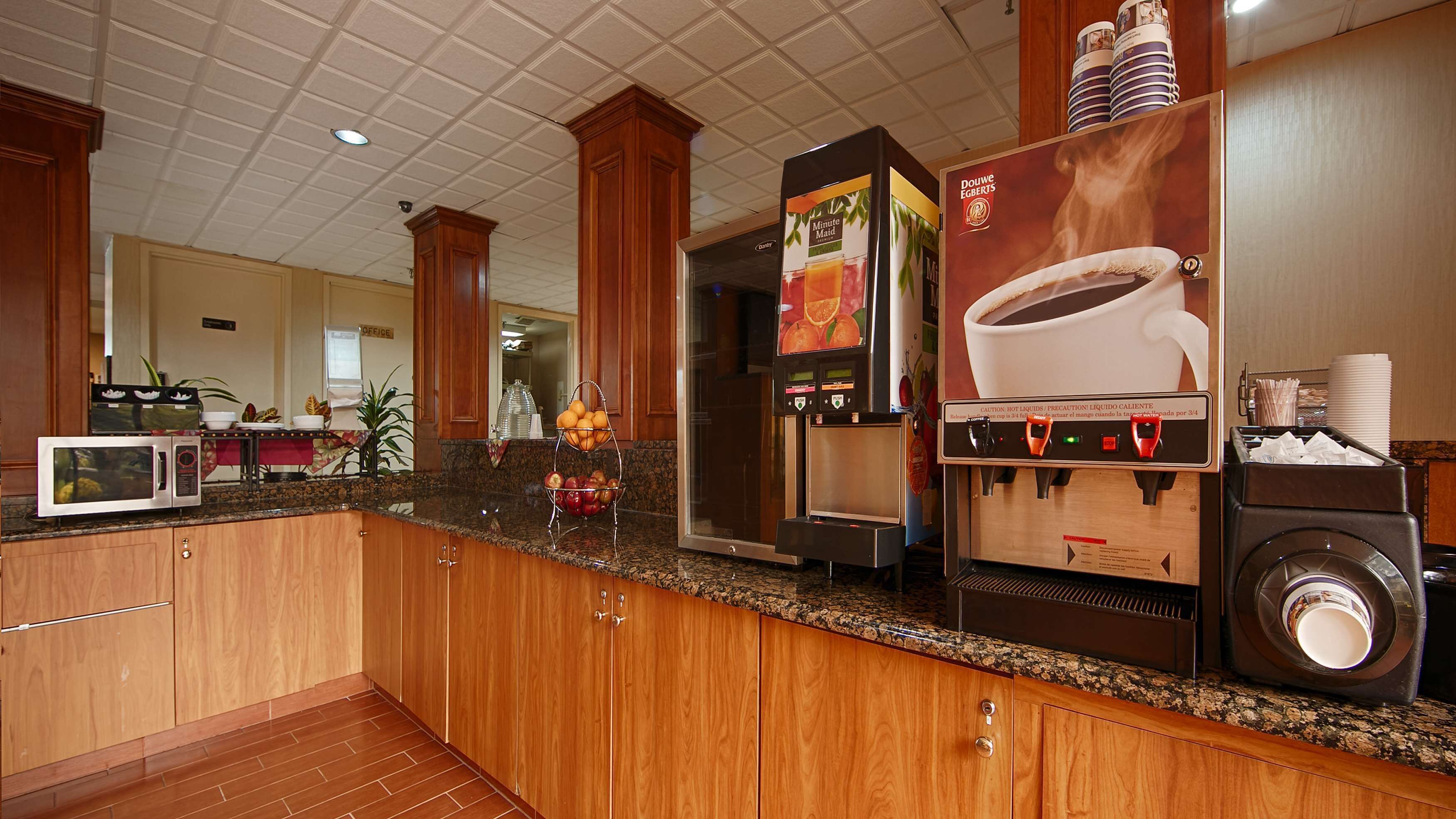 Une cuisine d’hôtel équipée d’une machine à café, d’un four à micro-ondes et d’un distributeur de café.