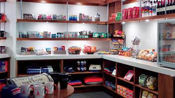 A store with shelves stocked with various products including snacks, beverages, and merchandise.
