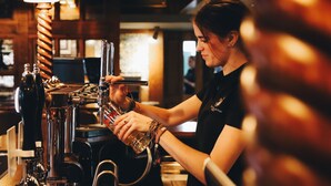 Una persona usando un grifo en un bar.