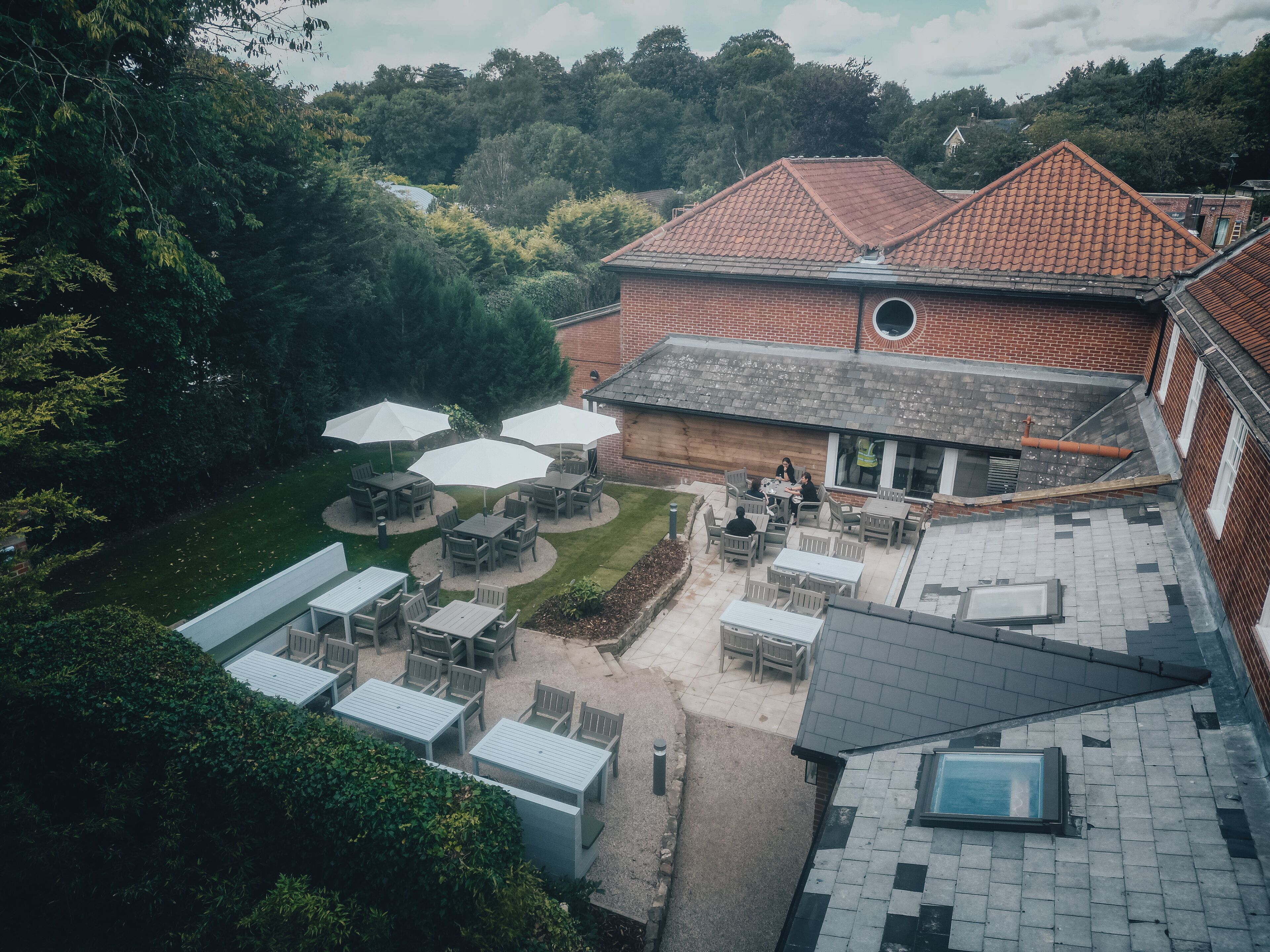 Een binnenplaats met terras en een bakstenen gebouw.