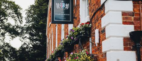 A brick building with a sign for The Knareesborough Inn.