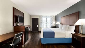 Une chambre d’hôtel équipée d’un lit, d’un bureau, d’une chaise, d’une télévision et de lampes.