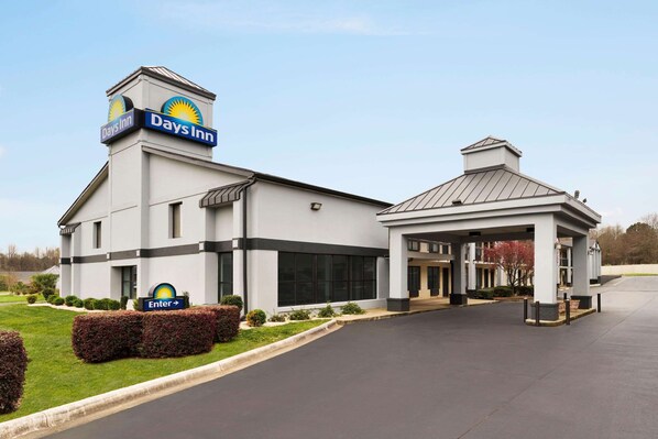 A Days Inn hotel with a modern design, featuring a prominent entrance, a covered waiting area, and a well-maintained lawn. - Days Inn by Wyndham Rock Hill (Rock Hill)