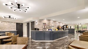 A spacious indoor area with a central kitchen island, seating arrangements, and modern lighting fixtures. - Days Inn by Wyndham Rock Hill (Rock Hill)
