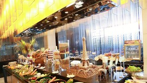 A buffet with various food items and a decorative Eiffel Tower centerpiece. - Jinglun Hotel Beijing (Beijing)