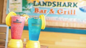 Two Landshark Bar & Grill branded drinks on a table with a blurred background of the establishment.