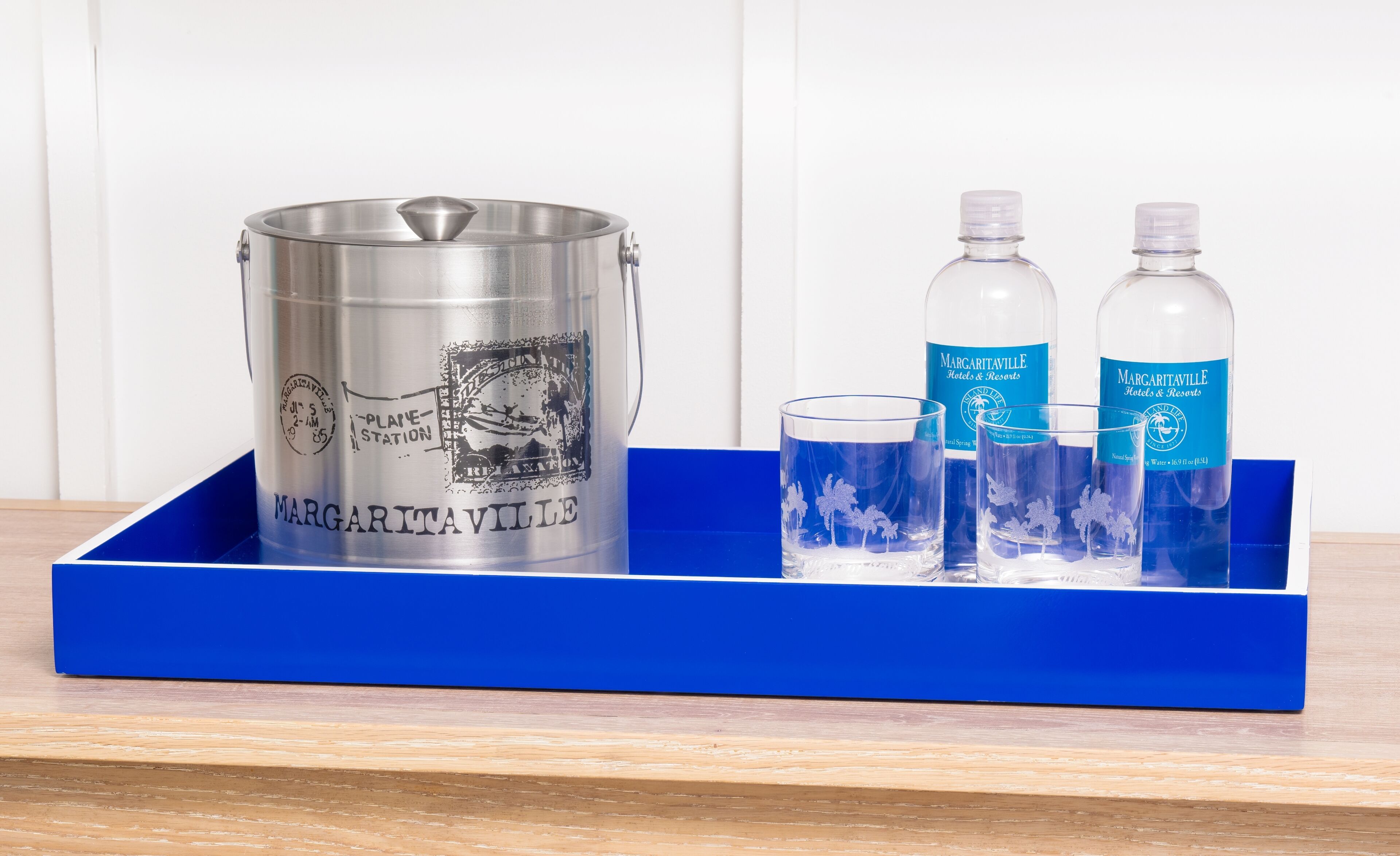 A blue tray with a silver bucket, two bottles, and two glasses.
