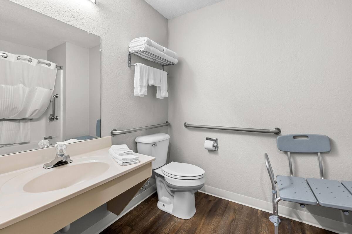 A modern bathroom with a sink, toilet, and a shower area.