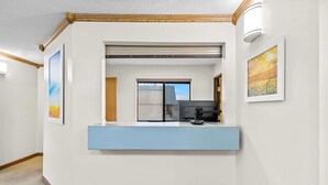 A reception area with a counter, a coffee machine, and framed artwork on the walls. - Days Inn by Wyndham Wall (Wall)