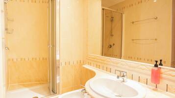 Un bagno con doccia, bidet, lavandino e specchio.