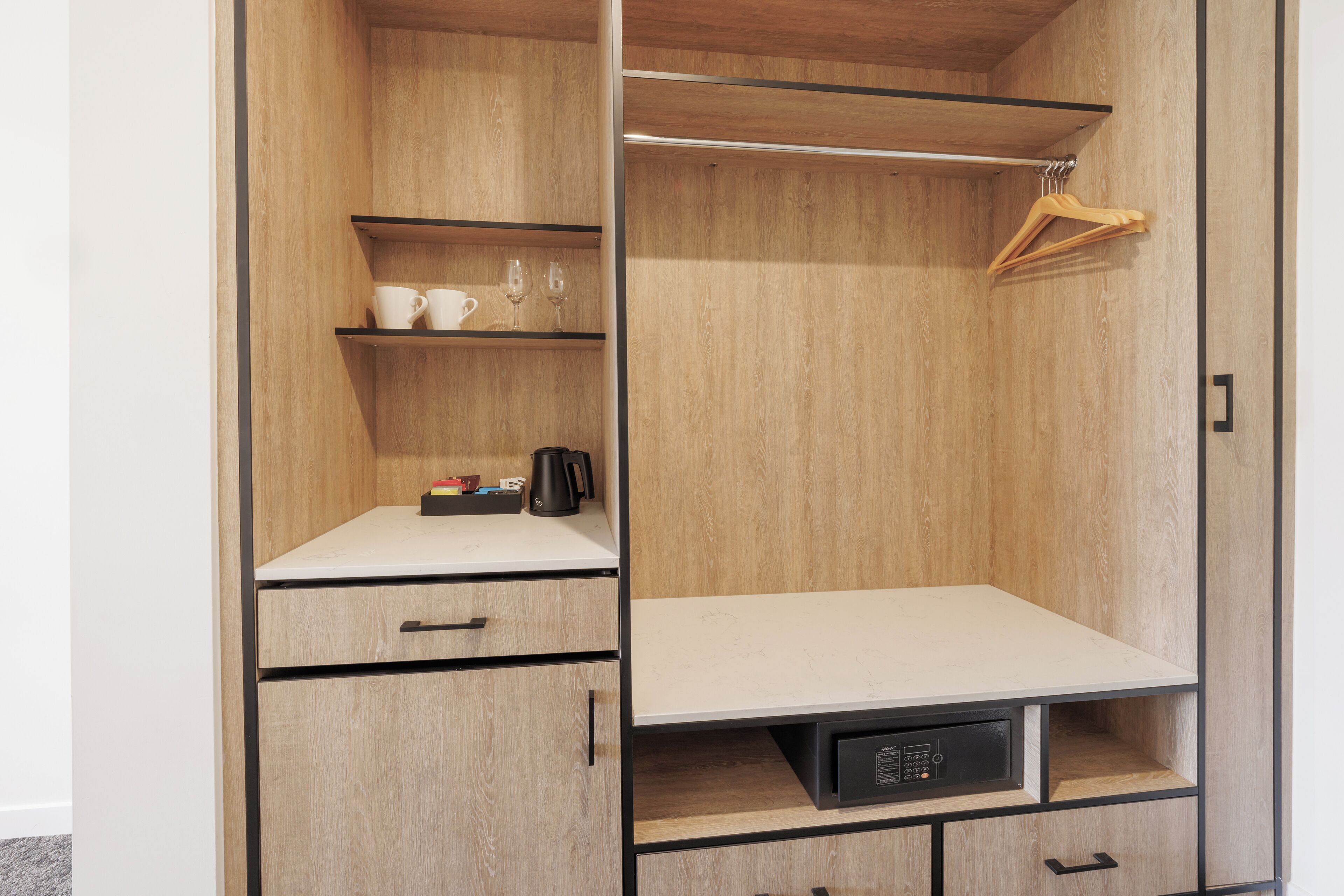 A wooden wardrobe with a countertop, shelves, and hanging space.
