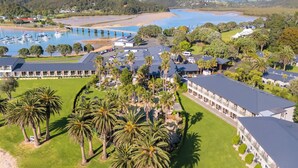 An aerial view of a resort with multiple buildings, a marina with boats, and a large body of water. - Copthorne Hotel and Resort Bay of Islands (Waitangi)