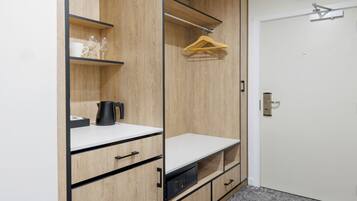 A wooden wardrobe with shelves, a hanging rack, and a door with a handle.