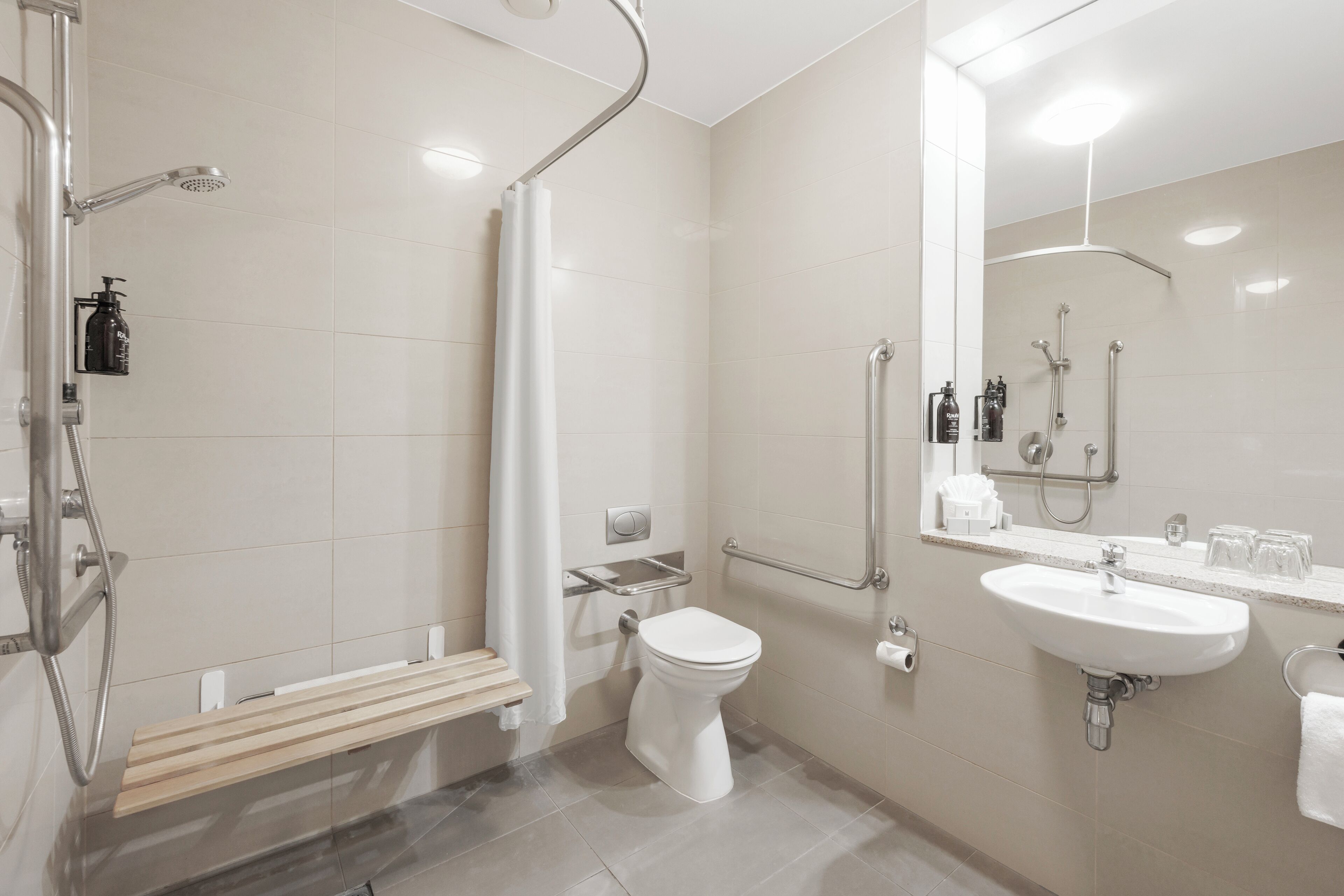 A modern bathroom with a shower, toilet, and sink.