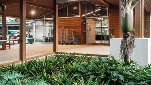 An indoor area with a wooden ceiling, large windows, and a central plant. - Copthorne Hotel and Resort Bay of Islands (Waitangi)