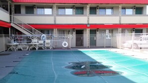 A swimming pool with a red roof, a staircase, and a fence. - Yakima Valley Inn (Yakima)