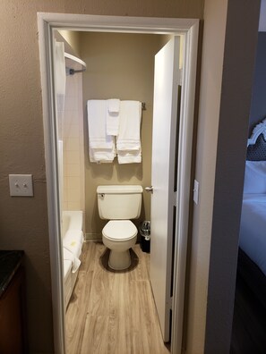 A compact bathroom with a toilet, a sink, and a towel rack.