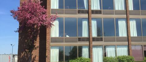 Un immeuble à plusieurs étages, doté de grandes fenêtres et d’une façade en briques.