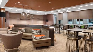 A modern lounge area with a sofa, armchairs, and a dining table. - SpringHill Suites by Marriott Beaufort (Beaufort)