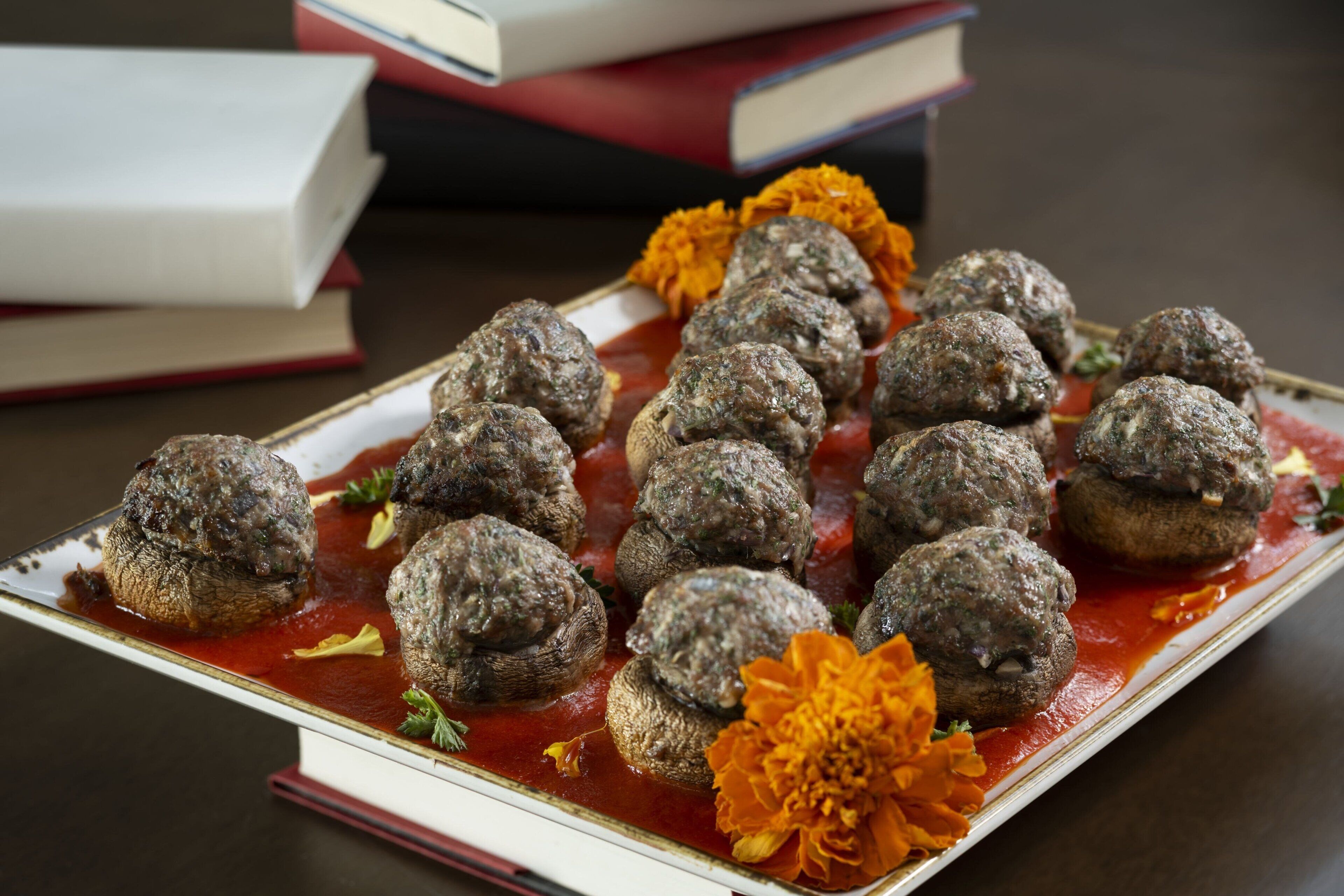A tray of meatballs in tomato sauce with a decorative flower.