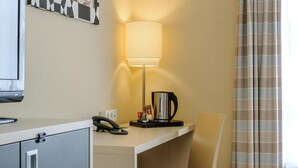 A hotel room with a desk, a telephone, a coffee maker, and a chair. - Sunday Hotel Berlin City West (Berlin)
