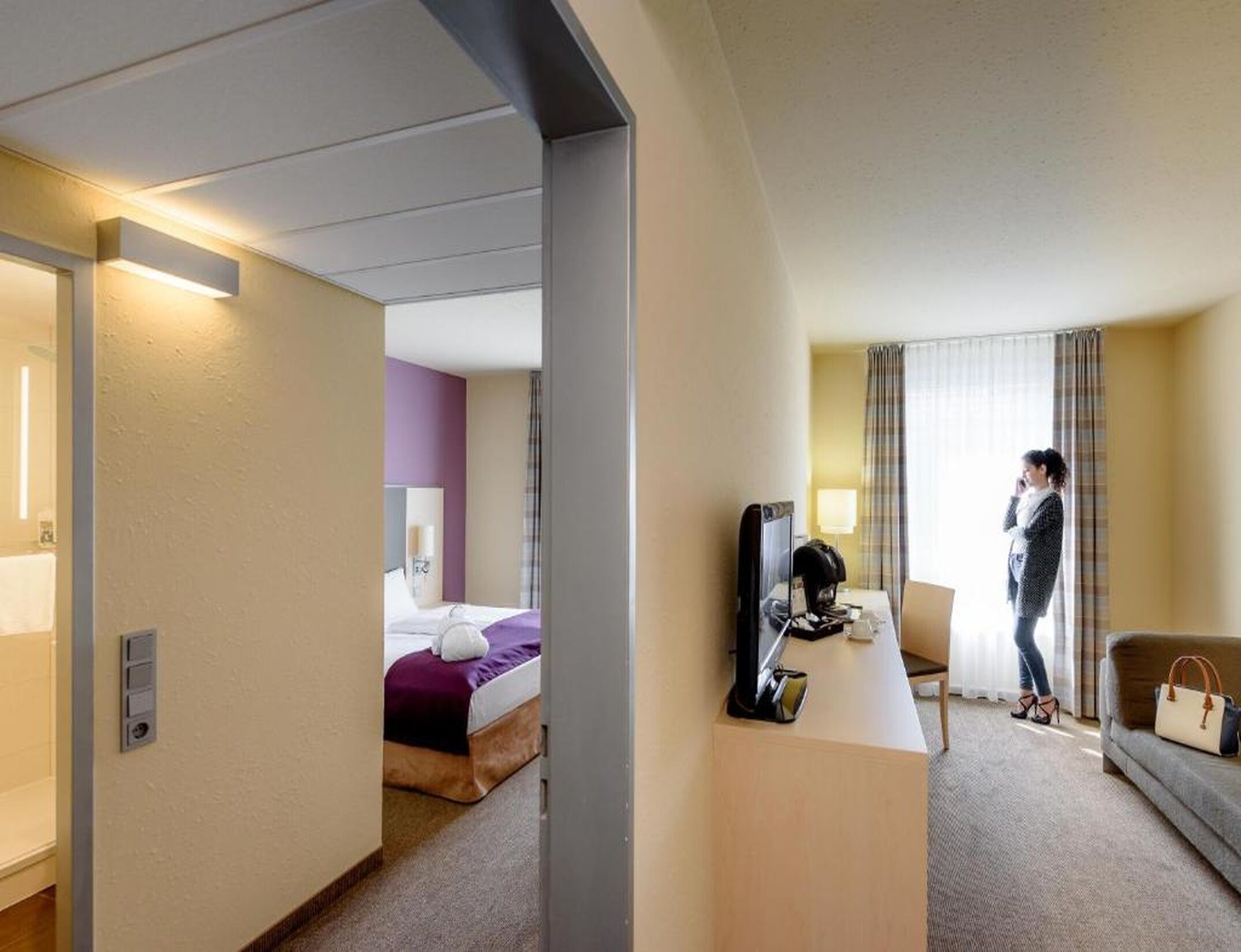 Ein Hotelzimmer mit einem Bett, einem Schreibtisch, einem Fernseher und einer Sitzecke.