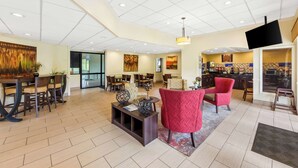 A spacious lobby with a high ceiling, modern furniture, and a flat-screen TV mounted on the wall. - Best Western Dayton (Dayton)