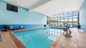 An indoor swimming pool with clear glass walls, blue walls, and a view of the outside. - Best Western Dayton (Dayton)