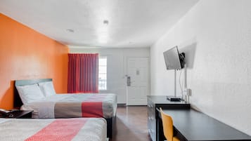 Une chambre d’hôtel avec deux lits, un bureau avec un ordinateur, une télévision et une fenêtre avec des rideaux.