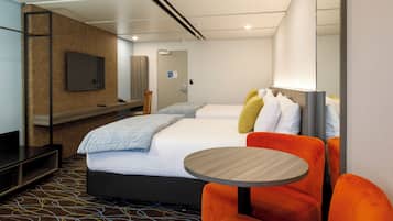 A modern hotel room with a bed, a TV, a desk, and a round table.