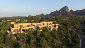 A modern hotel with a flat roof and multiple units, surrounded by dense forest and red rock formations. - Sky Rock Sedona, a Tribute Portfolio Hotel (Sedona)