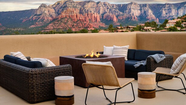 A patio with wicker furniture, a fire pit, and a view of red rock mountains. - Sky Rock Sedona, a Tribute Portfolio Hotel (Sedona)