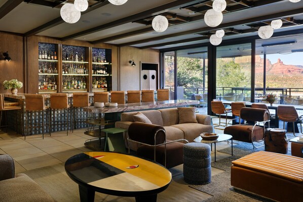A bar area with a bar counter, seating, and a view of the outdoors. - Sky Rock Sedona, a Tribute Portfolio Hotel (Sedona)