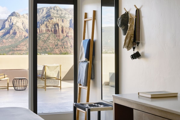 A room with a large window overlooking a mountainous landscape, a wooden ladder, a chair, and a hanging bag. - Sky Rock Sedona, a Tribute Portfolio Hotel (Sedona)