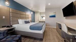 A modern hotel room with a large bed, a desk, a chair, and a flat-screen TV. - Best Western Orange Plaza (Orange)