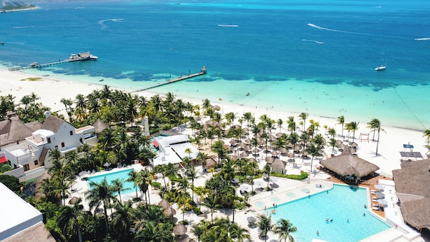 A resort with a large pool, palm trees, and a beach. - InterContinental Presidente Cancun Resort by IHG (Cancun)