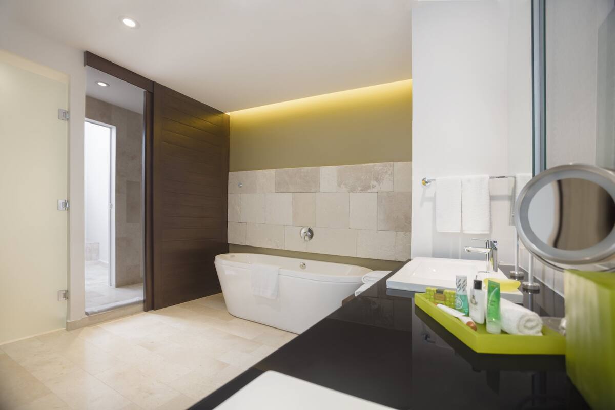 A modern bathroom with a bathtub, a sink, and a mirror.
