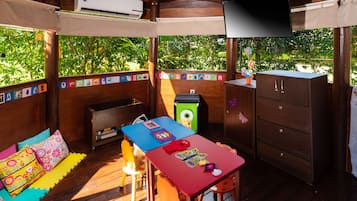 A wooden deck with a table, chairs, and a TV.