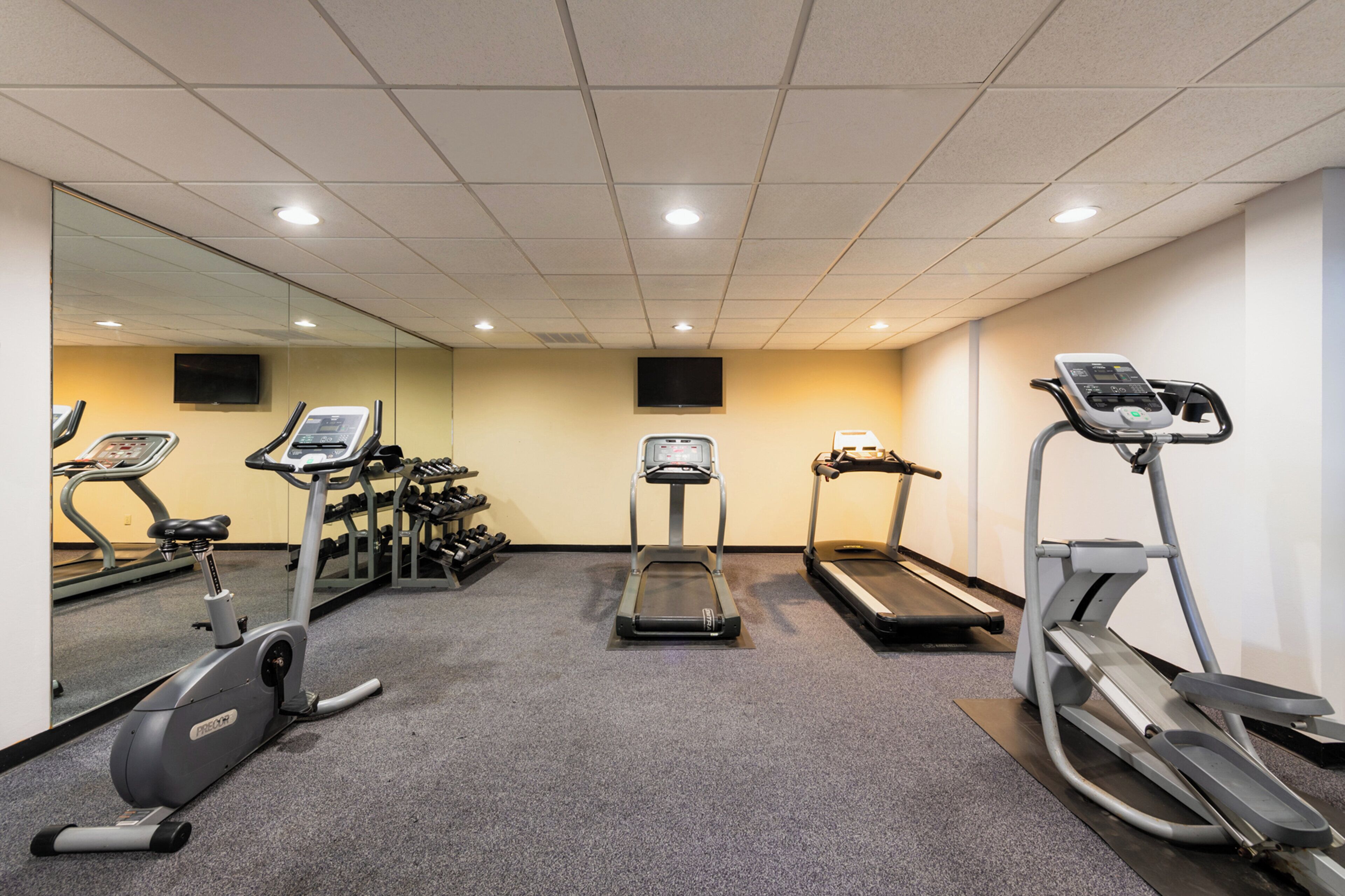 A gym with treadmills, an elliptical, and a stationary bike.