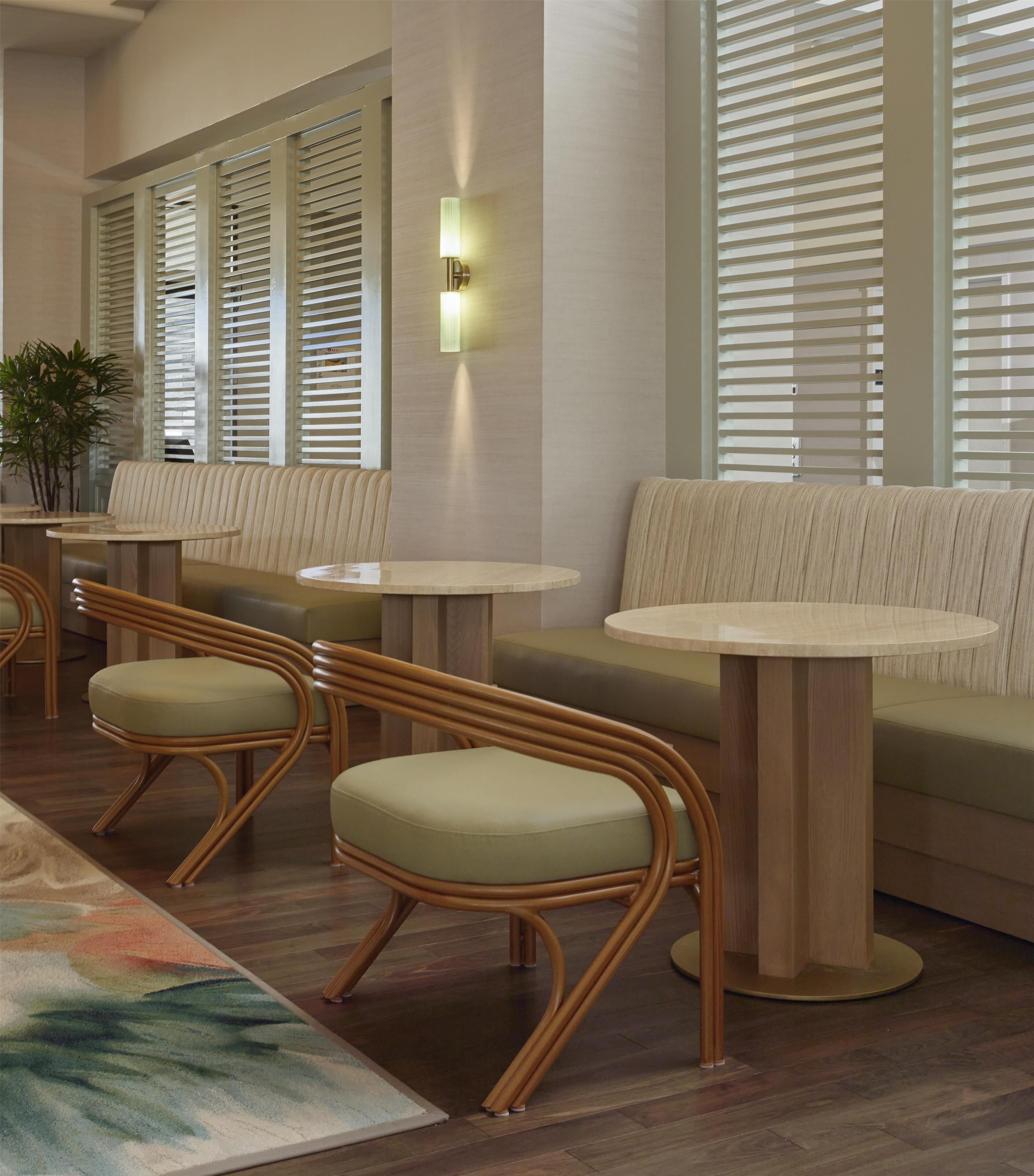 Un intérieur moderne avec des sièges disposés de manière conviviale, un luminaire fixé au mur et un tapis à motifs.