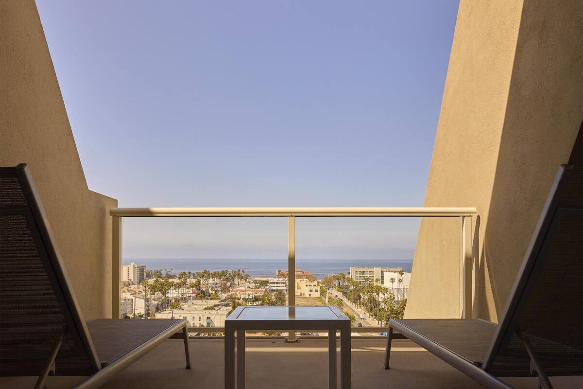 A balcony with a clear view of the cityscape and ocean.