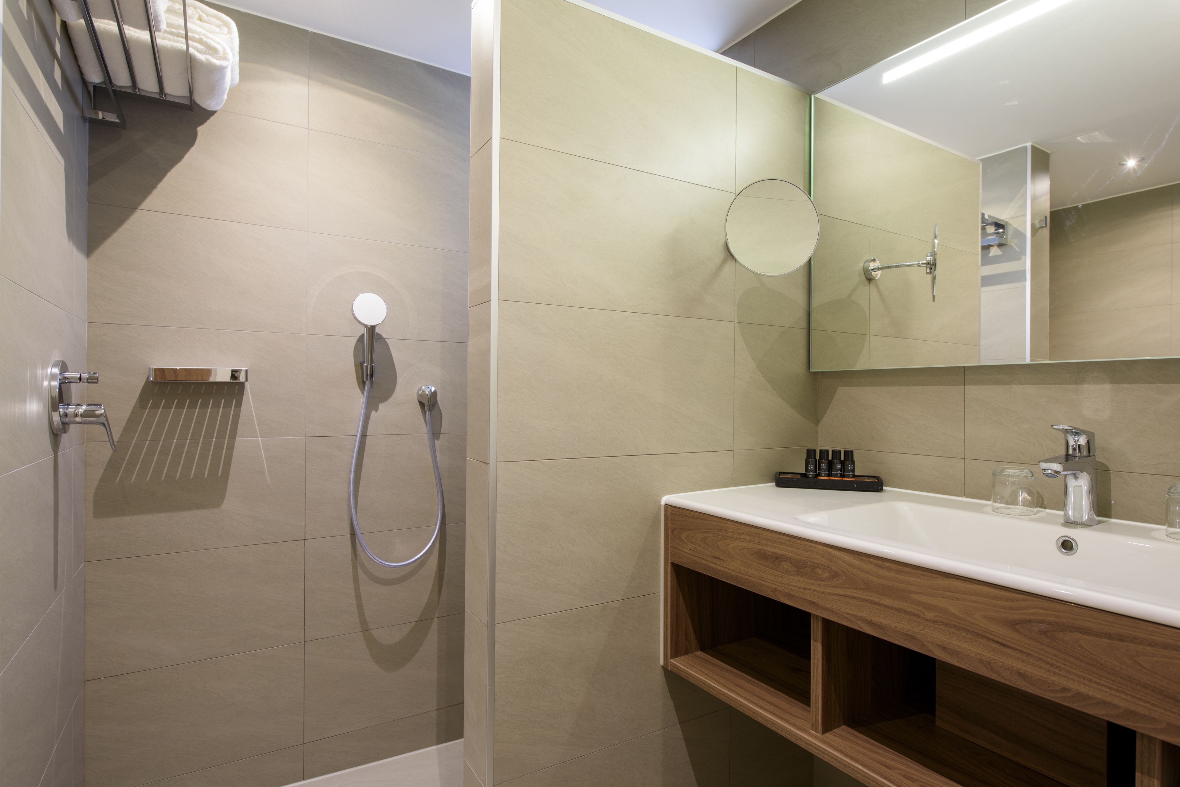 A modern bathroom with a shower, sink, and mirror.