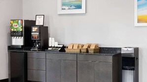 Eine Selbstbedienungsgetränkestation mit einer Kaffeemaschine, einem Dole-Saftspender und einem Avalon-Wasserspender.